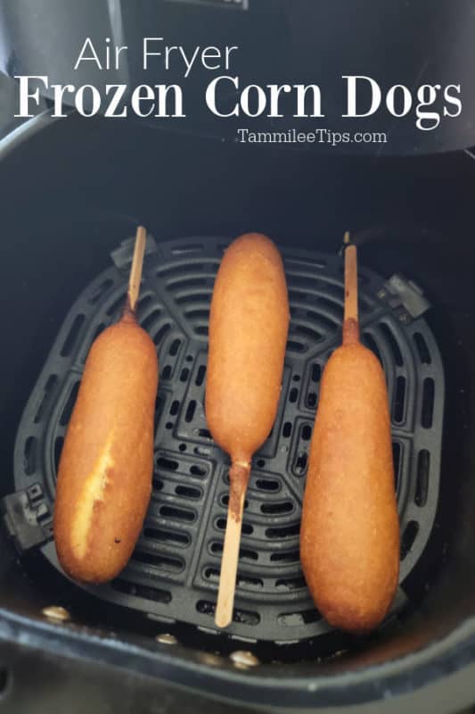Air fryer frozen corn dogs over an air fryer basket with three air fried corn dogs