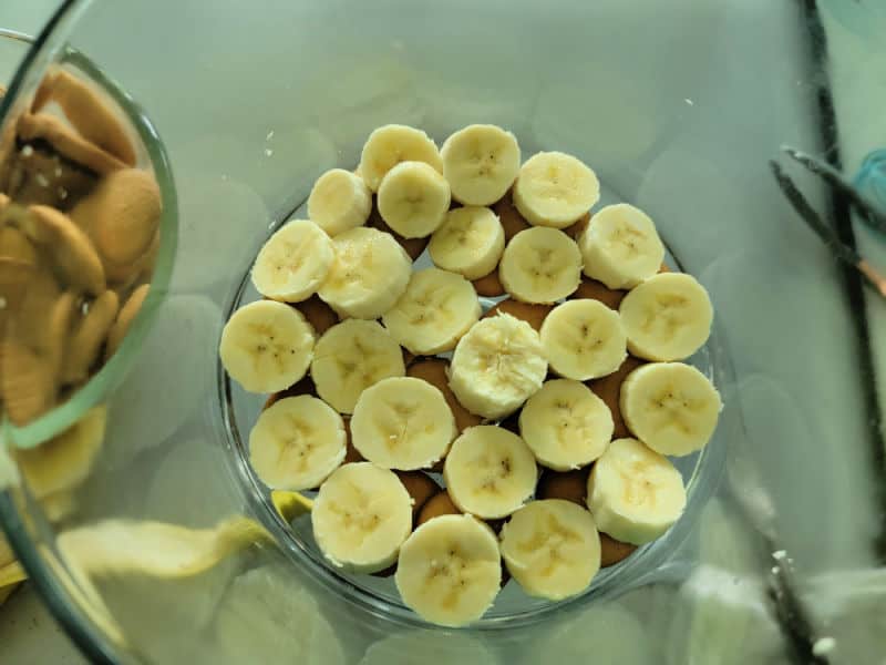 layer of nilla wafer and cut bananas to make Delicious Magnolia Bakery Banana Pudding Recipe in a glass trifle dish