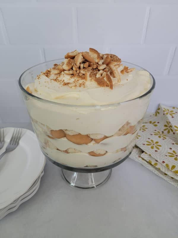Delicious Magnolia Bakery Banana Pudding Recipe in a glass trifle dish with crushed nilla wafers on top
