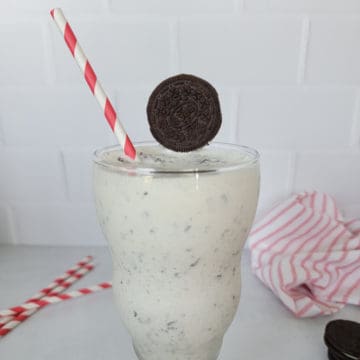 Oreo Milkshake Recipe in a shake glass with a red striped straw