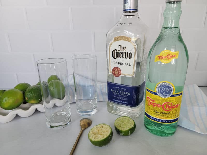 Ranch Water Drink ingredients, limes, tequila, Topo Chico, and 2 glasses