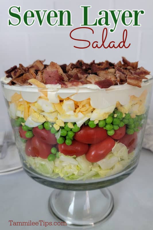 Seven Layer Salad text written over a trifle dish with 7 layer salad on a white counter. 
