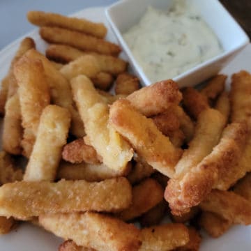 a plate filled with air fried fish sticks and dipping sauce