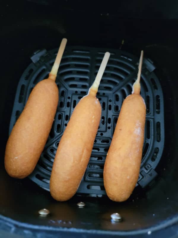frozen corn dogs in an air fryer basket