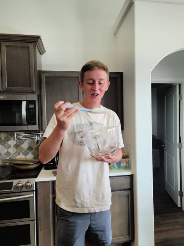 teenage boy with a spatula and glass bowl 