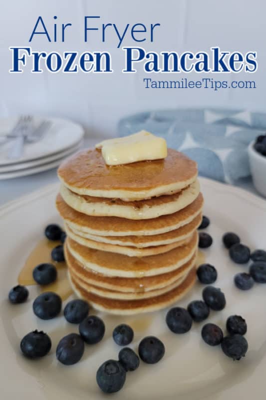 Air Fryer frozen pancakes over a stack of pancakes with butter and blueberries around it. 