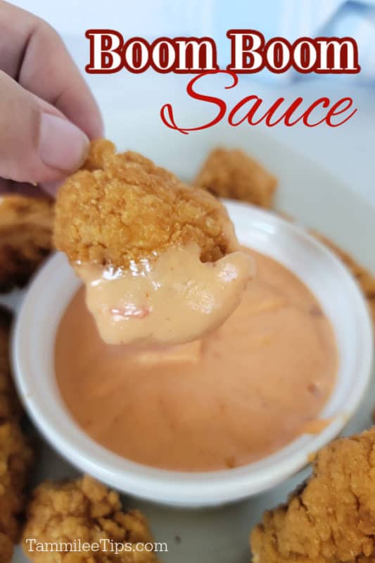 Boom Boom sauce over a Chicken nugget dipping into Boom Boom sauce in a white bowl 