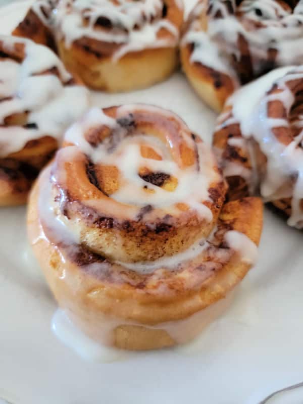 Cinnamon rolls with icing on a white plate