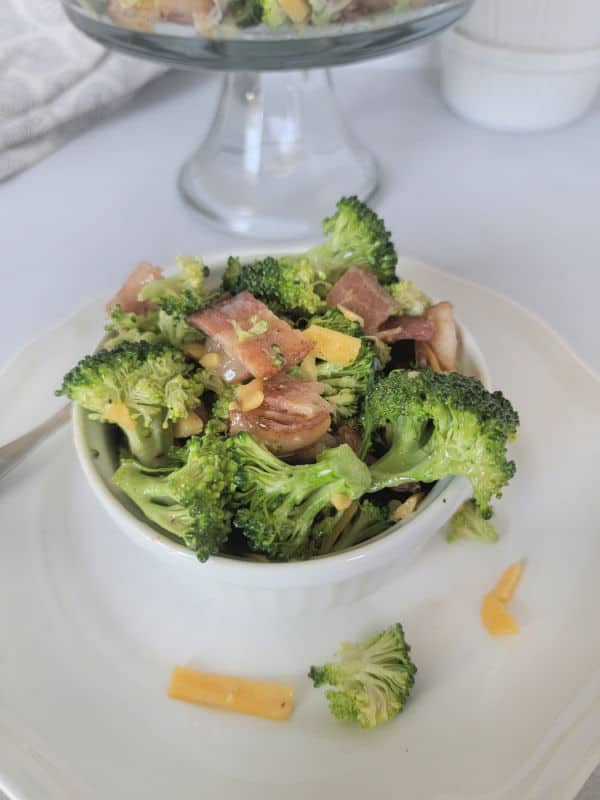 Broccoli salad with bacon in a white bowl 