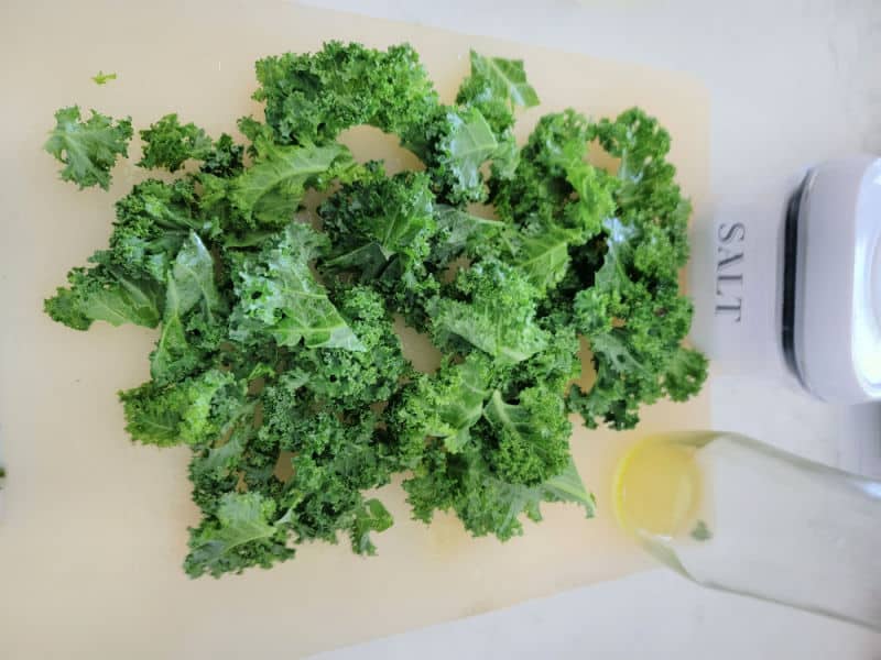 Kale on a cutting board by salt and oil