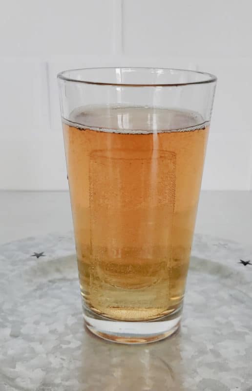 Shot glass inside of a full glass of liquid