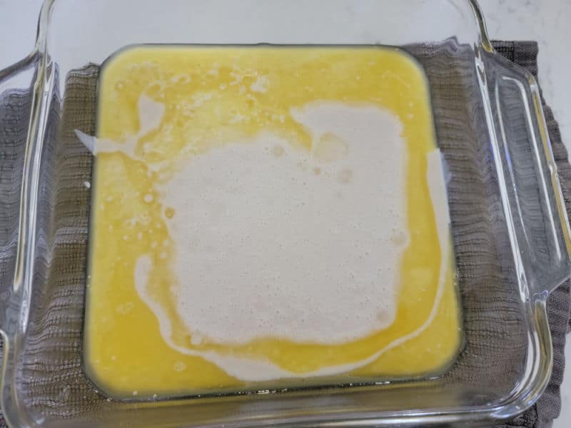 Bisquick poured into melted butter in a glass baking dish