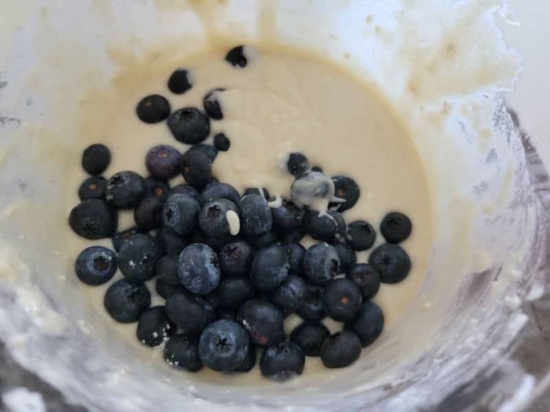 Fresh blueberries in a liquid batter in a glass bowl 