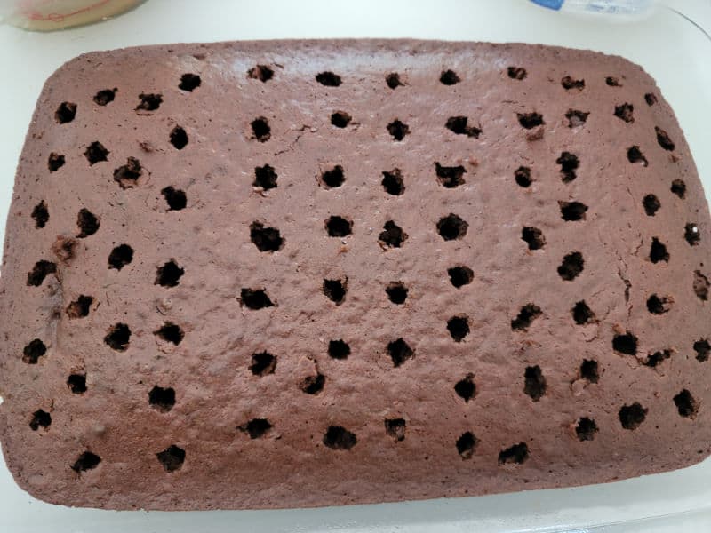 Chocolate cake with holes poked in it for Butterfinger Poke Cake