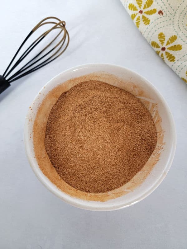 Cinnamon sugar in a white bowl with a whisk