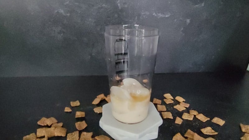 Cocktail shaker with liquid and ice in it net to Cinnamon Toast Crunch Cereal