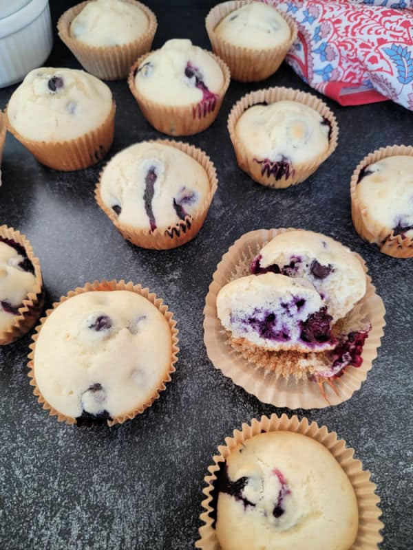 blueberry muffins in paper liners on a dark counter