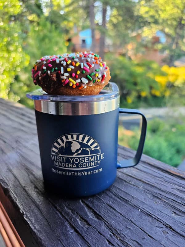rainbow sprinkle covered donut on a blue Yosemite Madera County coffee mug
