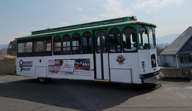 Oakhurst Trolley with a green roof and artober sign