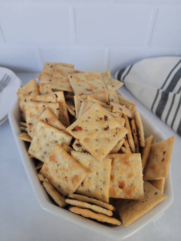 Alabama fire crackers in a white bowl next to a cloth towel and plates