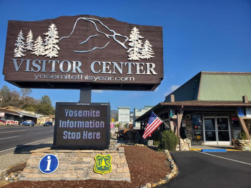 Visitor center sign with half dome and Yosemite information stop here