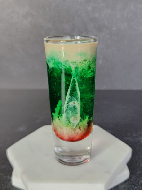 layered cream, green and red shot on two coasters