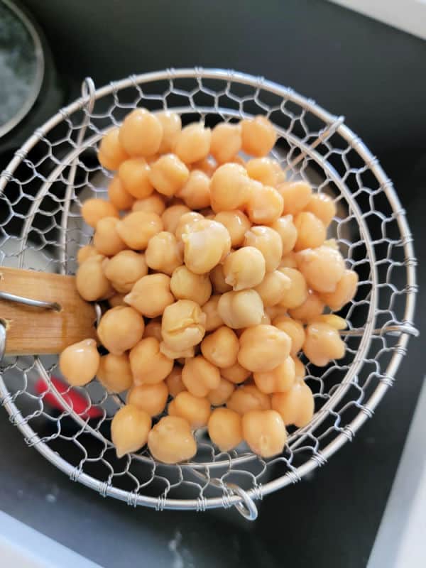 Chick peas in a strainer over the sink