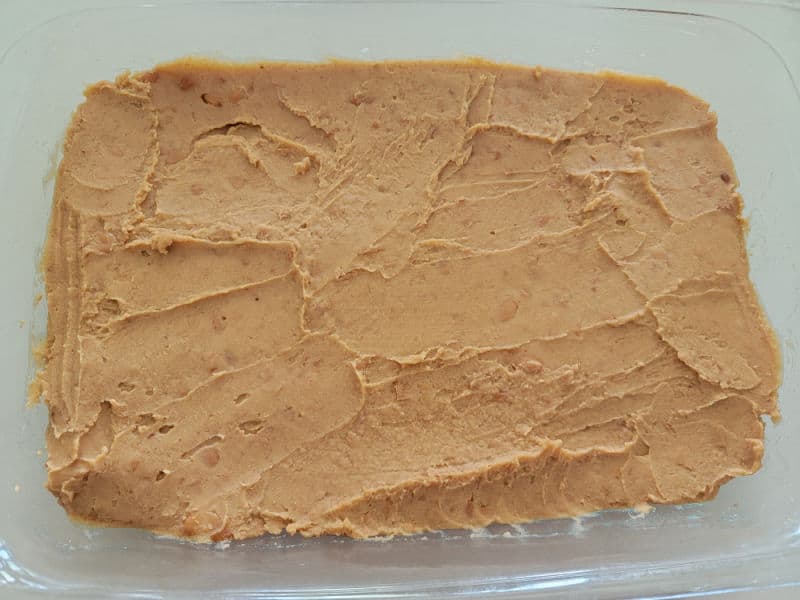 Refried beans spread in a glass baking dish