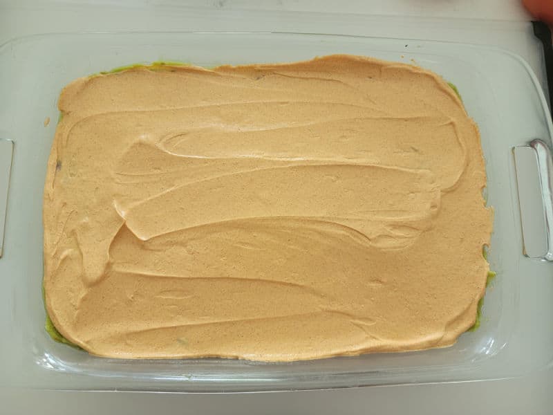 Sour cream mixture spread in a glass baking dish