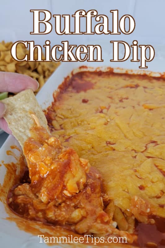 Buffalo Chicken Dip in a white casserole dish with a chip dipping into the buffalo chicken dip