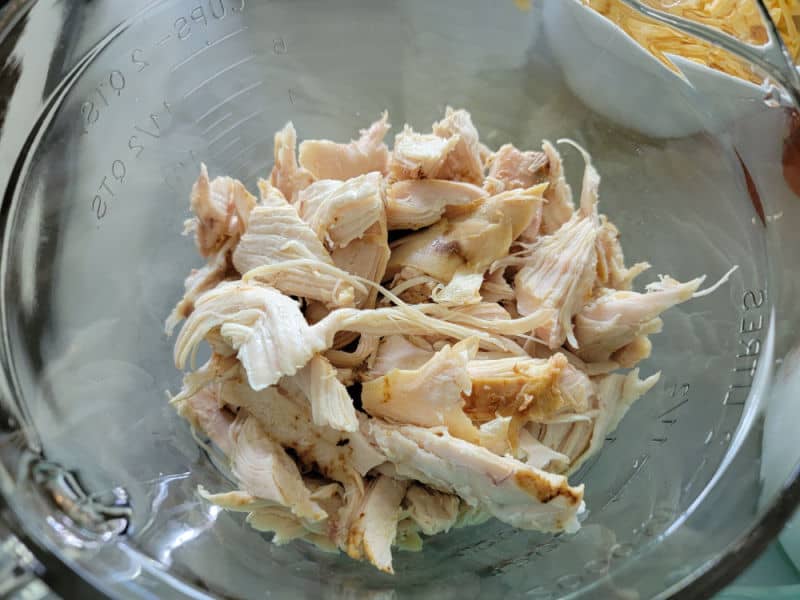 Shredded rotisserie chicken in a glass bowl