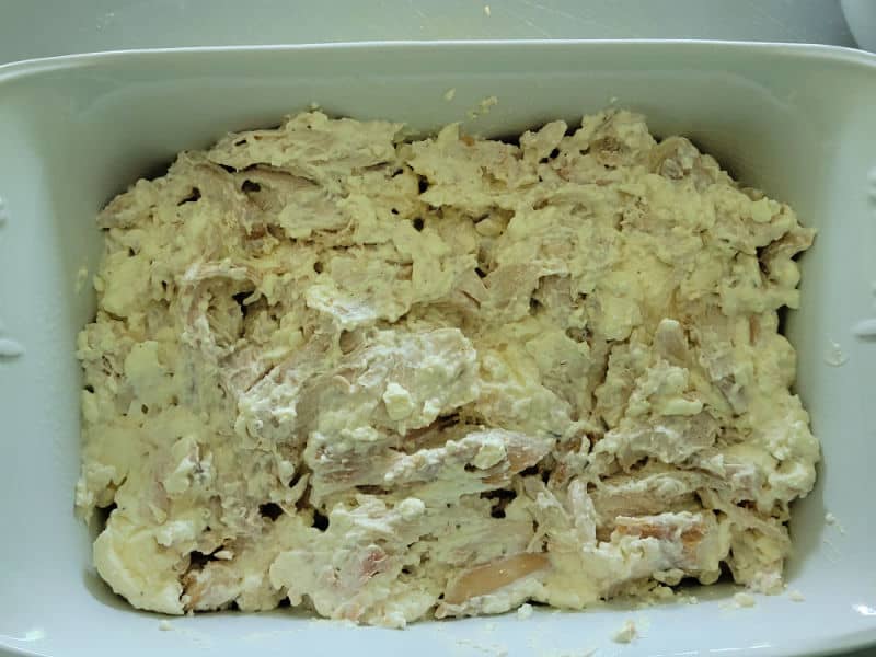 Buffalo chicken mixture spread in a casserole dish