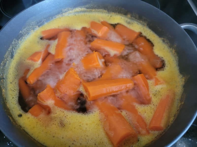 Carrots boiling in a dark saucepan for carrot souffle