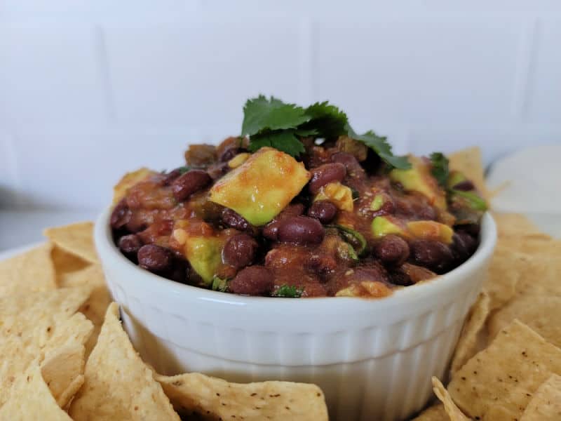 Black beans salsa in a white bowl surrounded by tortilla chips
