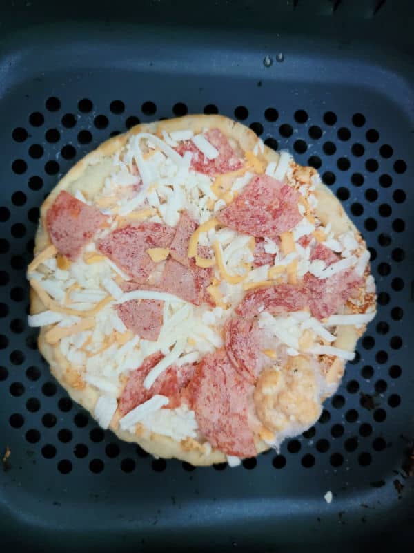 Frozen personal pepperoni pizza in an air fryer basket