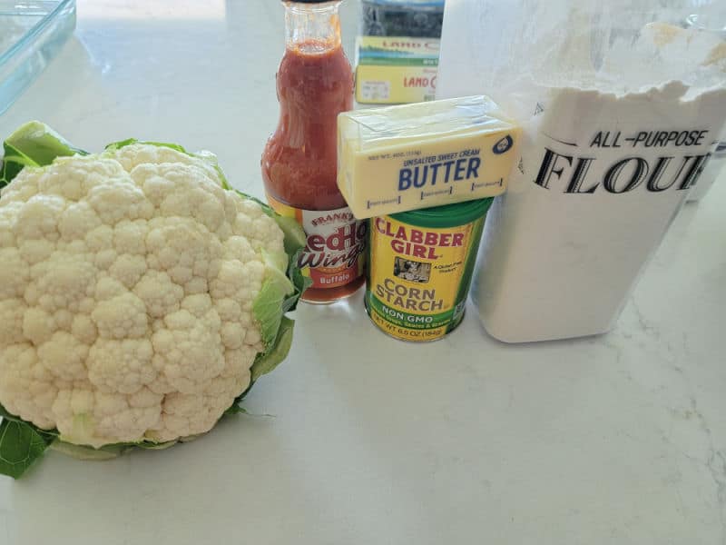cauliflower, buffalo sauce, butter, corn starch, and flour on a white counter