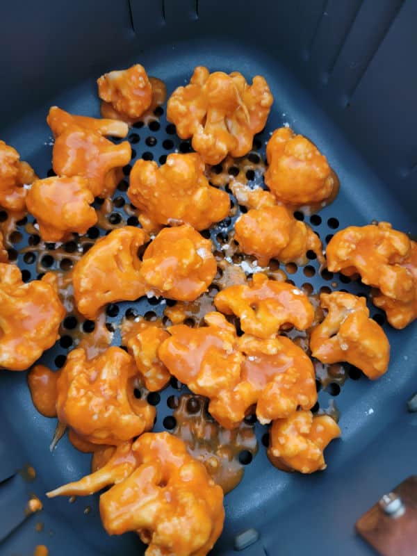 buffalo sauce coated cauliflower in the air fryer basket