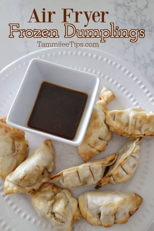 Air Fryer frozen dumplings over a white plate with dumplings and dipping sauce