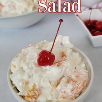 Individual serving of Ambrosia salad topped with a maraschino cherry