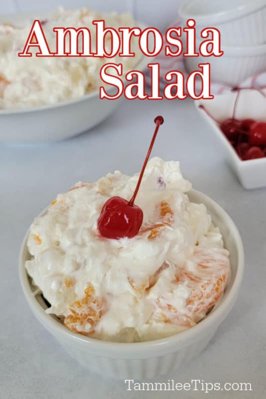 Ambrosia Salad over a white ramekin with fruit and a maraschino cherry