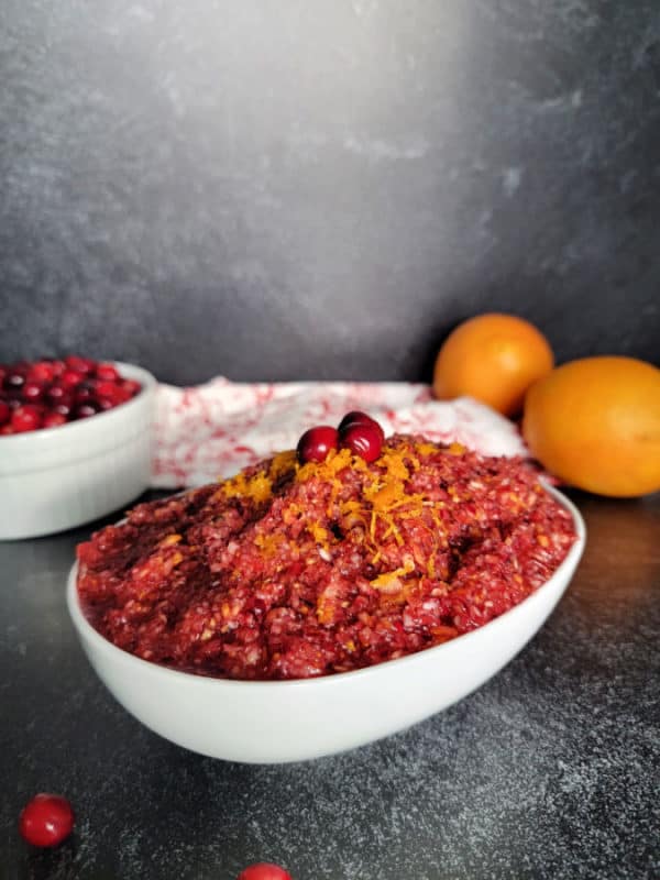 Cranberry Orange Relish garnished with fresh cranberries and orange zest in a white bowl