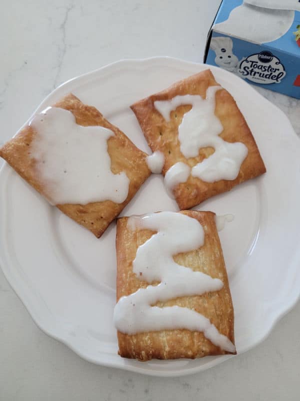 air fried toaster strudel with icing on a white plate