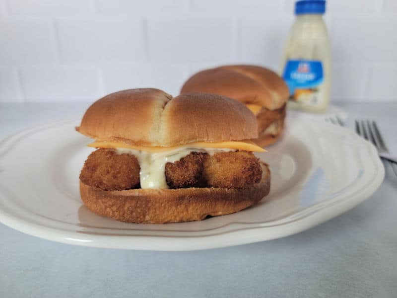 two air fried fish fillet sandwiches on a white plate