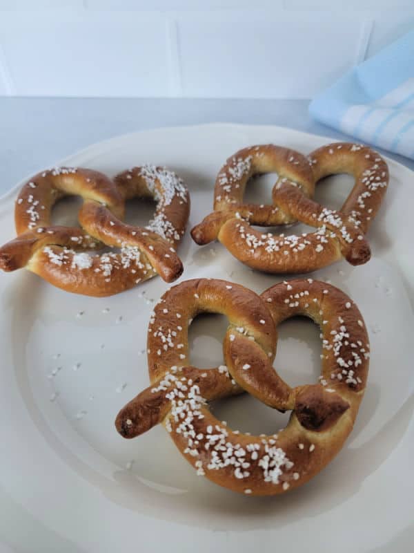 Three pretzels with salt on a white plate