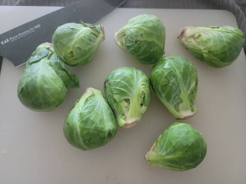 Brussel sprouts on a cutting board with a knife 