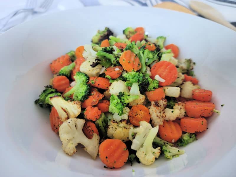 air fryer mixed frozen vegetables on a white plate with carrots, cauliflower, and broccoli. 