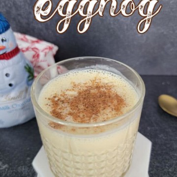 Bourbon Eggnog text over a glass cocktail glass with cinnamon garnish