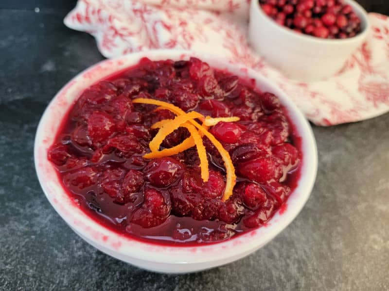 Easy cranberry sauce in a white bowl with orange strips