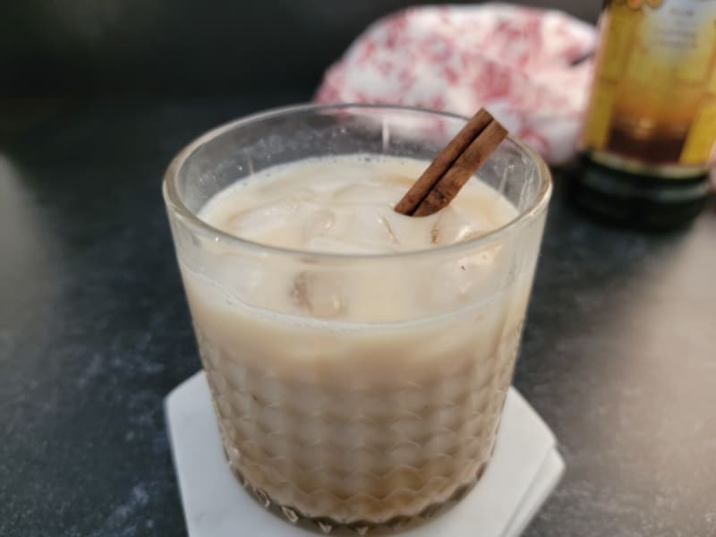 Eggnog White Russian cocktail in a crystal glass with a cinnamon stick