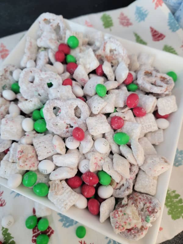 Reindeer chow with m&m in a white bowl on a holiday napkin